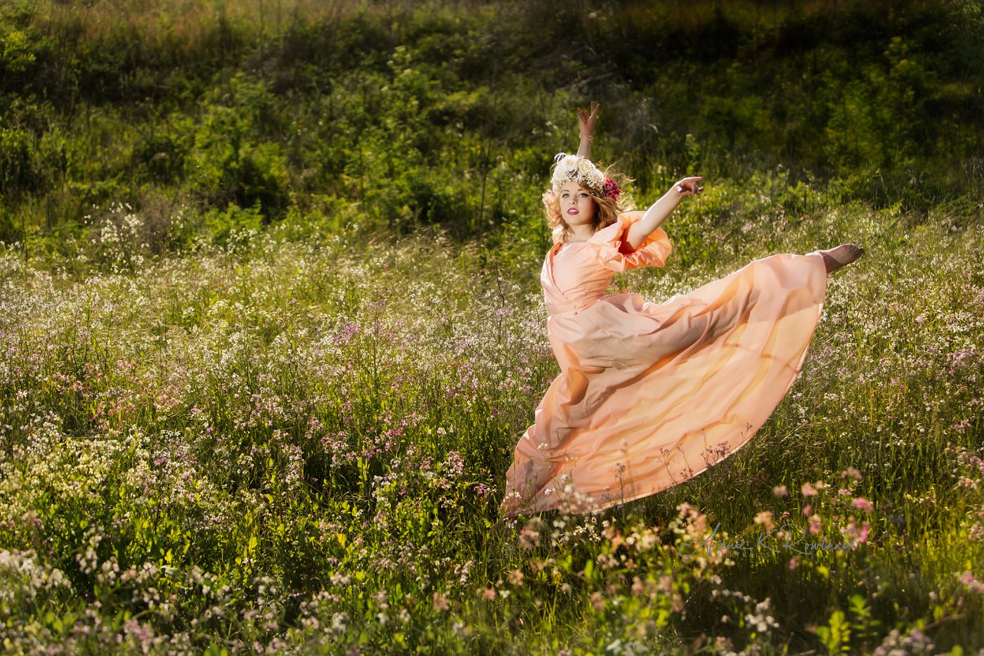 senior girl leapping in flower field